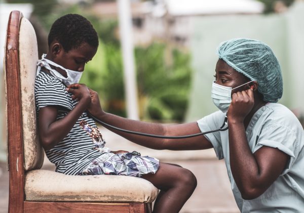 An African-American boy getting a checkup by a doctor